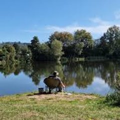Ein Mann der am Wasser sitzt und Angelt